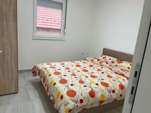 een slaapkamer met een bed met een dekbed en een raam bij 贝尔格莱德尼古拉特斯拉国际机场好运公寓2室1厅可住5人 in Surčin