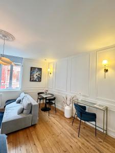 a living room with a couch and a table at L Amiens Haussmann-Gare-Hortillonnages-Centre-ville-WIFI in Amiens