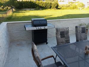 un patio con tavolo e griglia di Apartmani Ćućić a Lopar