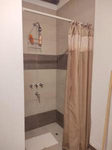 a shower with a shower curtain in a bathroom at Mantram Armonía in Mendoza +27 photos