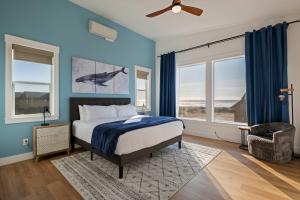una camera da letto con un letto con pareti e finestre blu di Brand-New Beach Retreat Hot Tub Sleeps 13 a Westport