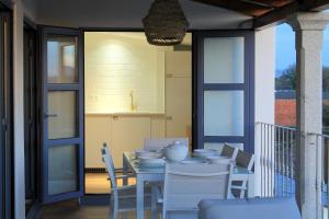 a porch with a table and chairs and a balcony at Hotel Apartamentos Casas da Fortaleza in Lugo