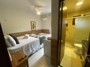 a bedroom with a bed and a bathroom with a shower at Pousada Monteflor Guaramiranga-CE in Guaramiranga +138 photos