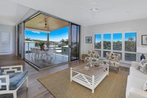 a living room with a white couch and a table at GEORGE8- THE ULTIMATE, FAMILY BEACH HOUSE! in Alexandra Headland