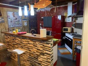 a kitchen with a brick counter and a red refrigerator at Chez HENRIETTE in Terre de Bas