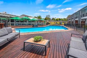 a deck with a pool with a couch and a table at Poenamo Hotel in Auckland