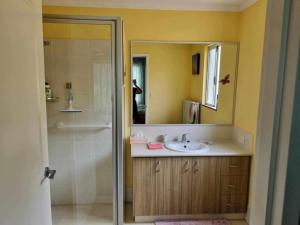 a bathroom with a sink and a shower with a mirror at Lavender Cottage at Nannup Lavender Farm in Nannup