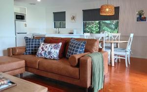 a living room with a brown couch and a table at The Cottages On Mount Tamborine in Mount Tamborine