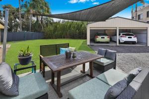 eine Terrasse mit Tisch und Stühlen und eine Autogarage in der Unterkunft NAROO7- PRIME, CENTRE OF MOOLOOLABA LOCATION in Mooloolaba
