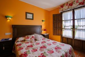 a bedroom with a bed with a floral bedspread at Hotel Camangu in Camango