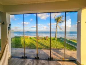 a room with a view of the ocean at Casa Pé na Areia in Balneario Barra do Sul +1 photo