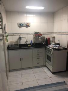 a kitchen with a sink and a stove at Recanto Santa Helena Iriri Santa Helena in Anchieta