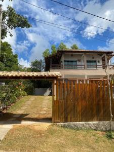 a house with a wooden gate and a fence at Recanto Santa Helena Iriri Santa Helena in Anchieta