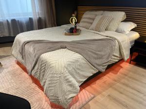 a bed with a blanket on it with a tray on it at L'élégance - Suite Romantique - Jacuzzi Privatif in Sarrebourg