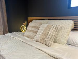 Una cama con sábanas blancas y almohadas. en L'élégance - Charme - Jacuzzi - -Secret- Parking, en Sarrebourg 26 fotos más