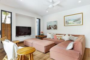 Una sala de estar con dos sofás y un televisor. en Oceanic-Pet Friendly Townhouse 8min to Mooloolaba, en Parrearra