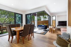 Un comedor y una sala de estar con mesa y sillas. en Oceanic-Pet Friendly Townhouse 8min to Mooloolaba, en Parrearra