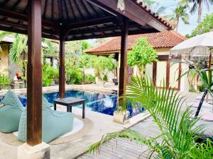 an outdoor swimming pool with a pavilion next to a house at Pondok Baruna Garden in Nusa Lembongan