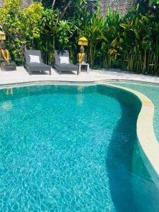 a swimming pool with blue water in a resort at Villa Bali Santai in Kerobokan