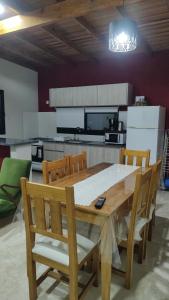 una cucina con tavolo da pranzo e sedie in legno di Mis Dos corazones a Villa Gesell