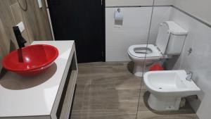 bagno con lavandino rosso e servizi igienici di Mis Dos corazones a Villa Gesell
