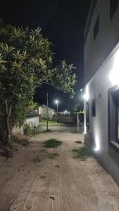 un albero è in piedi accanto a un edificio di notte di Mis Dos corazones a Villa Gesell Altre 3 foto