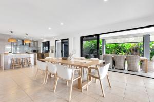 una sala da pranzo e una cucina con tavolo e sedie di YALLA24-Luxury Resort Style Home a Mooloolaba