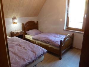 Duas camas num pequeno quarto com uma janela. em Schiefferberg em Bernardvillé