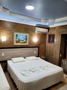 ein Schlafzimmer mit einem großen Bett mit weißer Bettwäsche in der Unterkunft Pousada Porto dos Corais in Maragogi