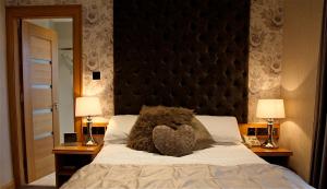 a stuffed animal sitting on a bed with two lamps at The Royal Hotel in Cookstown