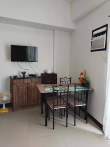 a dining room with a table and chairs and a tv at Perfect Budget Stay Near Airport in Pusok