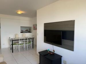 Il comprend un salon doté d'une table et d'une télévision à écran plat. dans l'établissement Apartamento Vista Mar, à Maceió