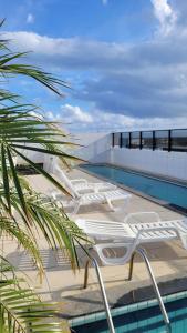 une piscine au sommet d'un immeuble avec un palmier dans l'établissement Apartamento Vista Mar, à Maceió