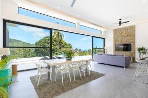 a living room with a table and chairs and a large window at VILLA CAMILLE - SEAVIEW - 4 Bedrooms in Koh Samui 