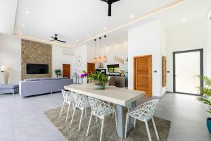 a dining room and living room with a table and chairs at VILLA CAMILLE - SEAVIEW - 4 Bedrooms in Koh Samui 