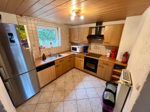 a kitchen with wooden cabinets and a stainless steel refrigerator at Haus Allbach in Namborn