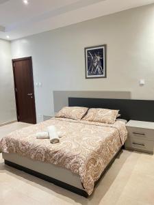 达喀尔Logement standing moderne au centre de Dakar的一间卧室配有一张大床和一个床头柜