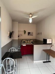 a room with a bed and a kitchen with a table at Casa da Vó Maria 08 in Goiânia