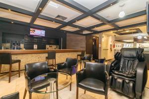 a bar with black leather chairs and a counter at Apartamento incrível prox. shopping curitiba in Curitiba