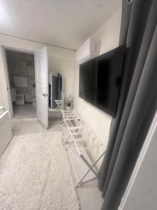 a living room with a flat screen tv on a wall at Luxury Apt for 4 Comfy Quiet AC & WiFi in San Felipe de Puerto Plata