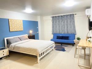 Ban Khlong SamrongLa Maison 230的一间带床和蓝色墙壁的卧室