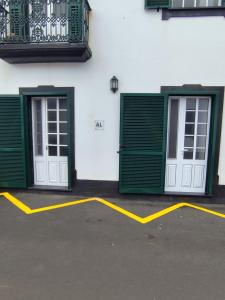 two green and white doors on a building at Casa da Praça I in Vila Nova +6 photos