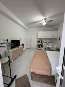 a bedroom with a large bed and a kitchen at Casa da Praça I in Vila Nova