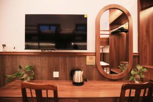 una TV a parete con tavolo e specchio di Lotus Hotel Đà Lạt a Khu Chi Lăng
