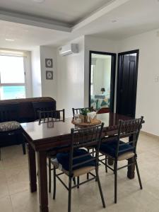 Un comedor con mesa y sillas de madera. en Suite vista al Mar Salinas, en Salinas