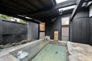 a swimming pool in front of a house at Shikinosato Hanamura in Minamioguni