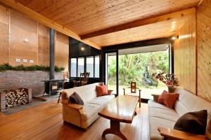 a living room with a couch and a fireplace at Shikinosato Hanamura in Minamioguni