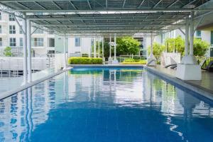 a swimming pool with blue water in a building at Perfect Staycation at Abreeza Mall with Kitchen, Netflix, Resort-style Pool - Davao Stay Suites T2-815 in Davao City
