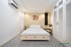 a bedroom with a white bed and a desk at Libra Hotel Residence by Luxe Paradise in Hanoi