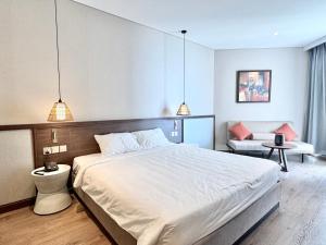 une chambre avec un grand lit blanc et un canapé dans l'établissement CONDOTEL APEC Mũi Né, à Ấp Thiẹn Ái 32 autres photos